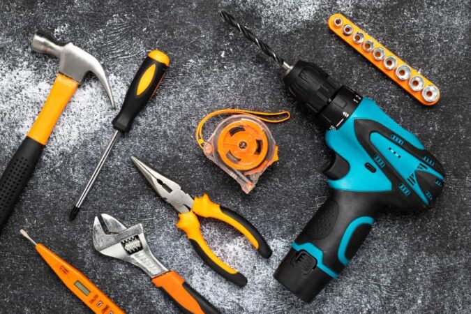 Outils de bricolage variés posés sur une surface sombre, révélant des symptômes d'inefficacité dans l'utilisation de vos outils