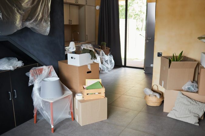 Salon moderne en plein tri avec de nombreux cartons et objets emballés, prêt pour un débarras de maison efficace