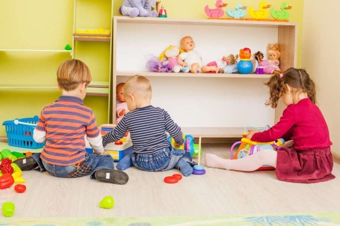 Des enfants jouent joyeusement ensemble dans une salle de jeux colorée pour marquer l'entrée à l'école maternelle.